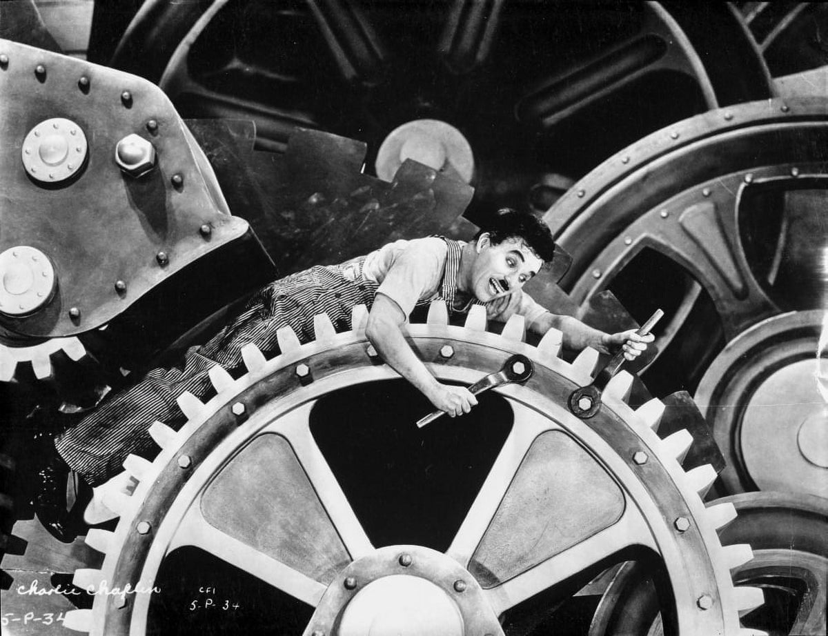 Charlie Chaplin film still photo print depicting comedic entanglement in machinery.