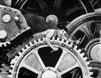 Charlie Chaplin film still photo print depicting comedic entanglement in machinery.