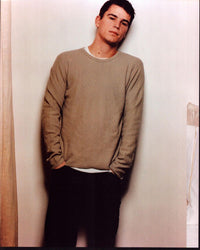 Josh Hartnett photo print in tan sweater against wall.