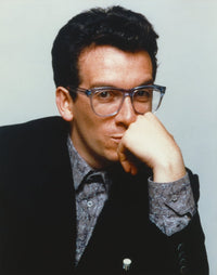Elvis Costello leaning chin on hand in black tuxedo photo print