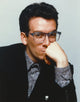 Elvis Costello leaning chin on hand in black tuxedo photo print