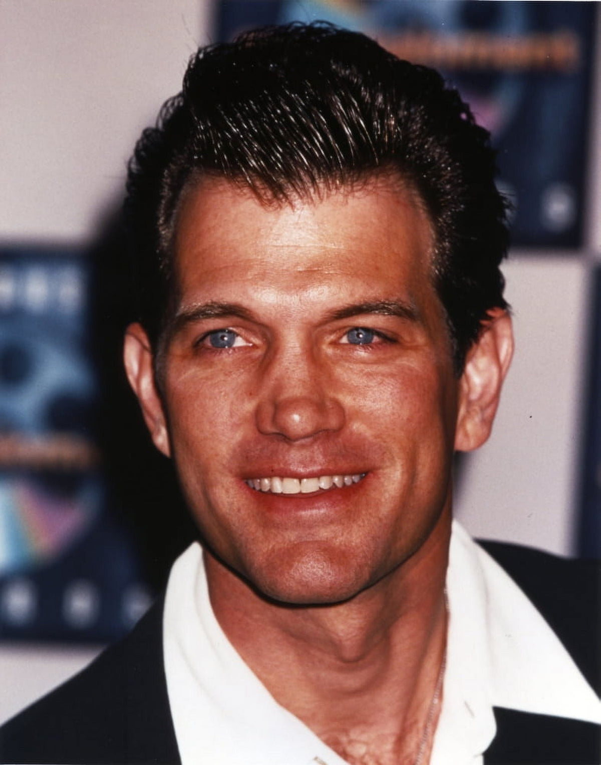 Close-up portrait photo print of Chris Isaak in black coat with white collar.