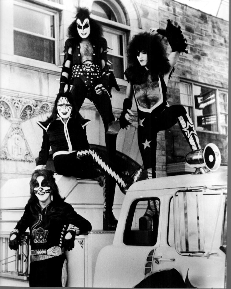 Black and white photo print of Kiss band on top of cars
