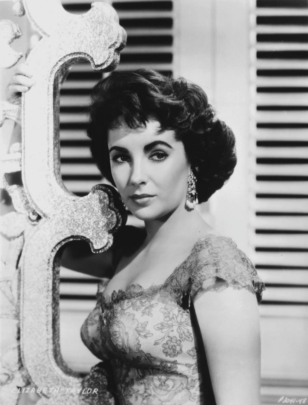 Black and white photo print of Elizabeth Taylor posing elegantly with earrings.