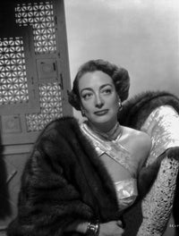 Classic photo print of Joan Crawford looking away from the camera while leaning on a chair.
