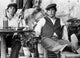 Photo print of Marlon Brando seated with a man holding a gun.