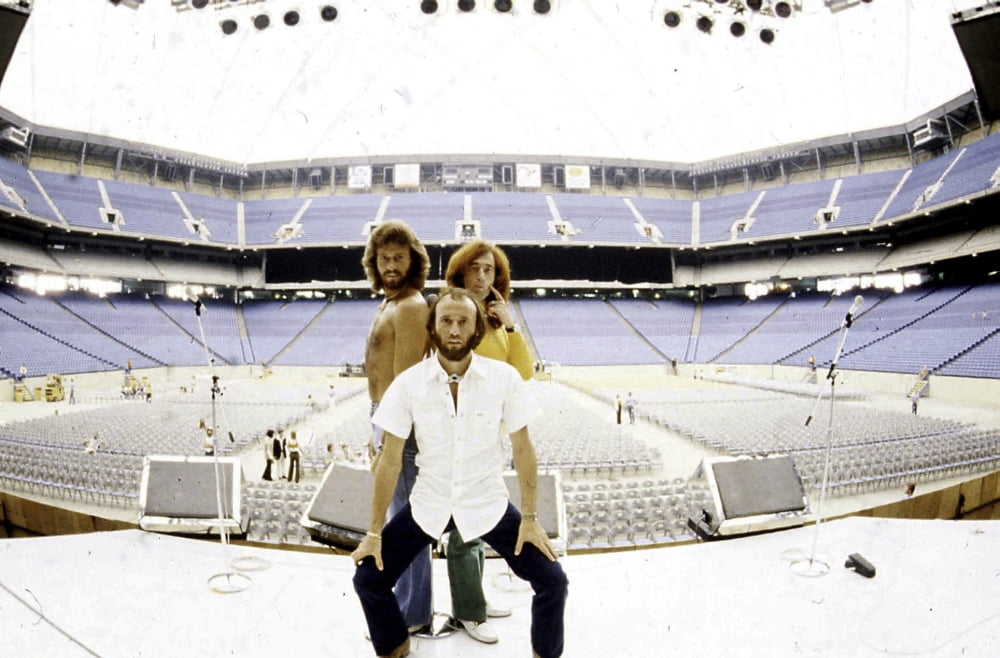 Bee Gees live performance photo print capturing the band on stage in an empty stadium.