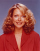 Susan Blakely smiling in a red sweater photo print.