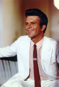 Photo print of Anthony Denison seated in white coat.