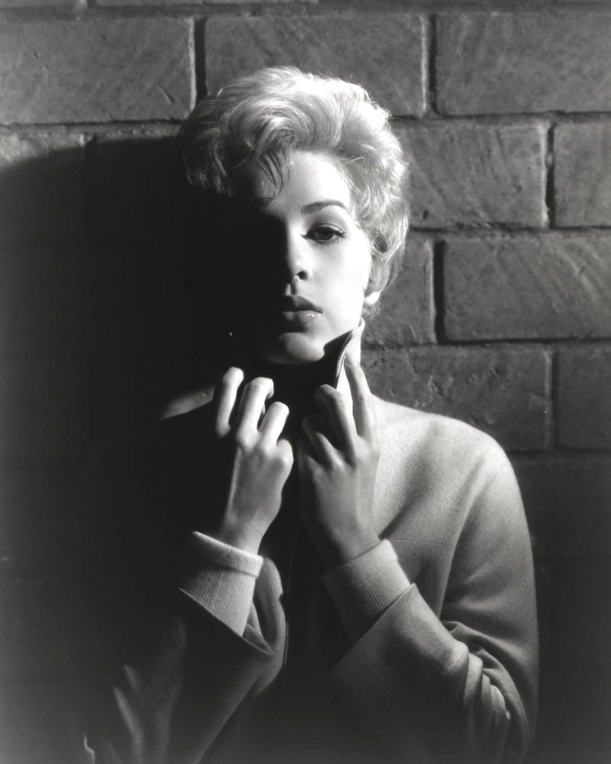 Black and white portrait of Stella Stevens wearing a turtle neck sweater.