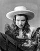 Ella Raines serious pose in cowgirl outfit photo print.