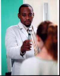 Omar Epps in lab coat with patient on set of House M.D. photo print.