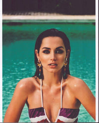 Ana De Armas lounging in a pool wearing a striped halter top photo print.
