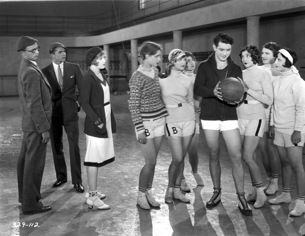 Black and white photo print of Marion Davies surrounded by people.