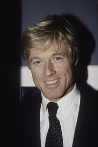 Robert Redford wearing a black tie in a classic photo print.
