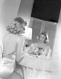 Gloria Grahame looking in a mirror wearing a backless dress photo print