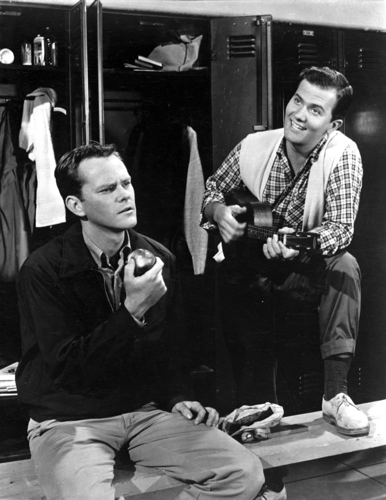 Pat Boone playing guitar in a locker room film still photo print.