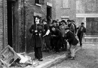 Charlie Chaplin walking on street photo print with men following