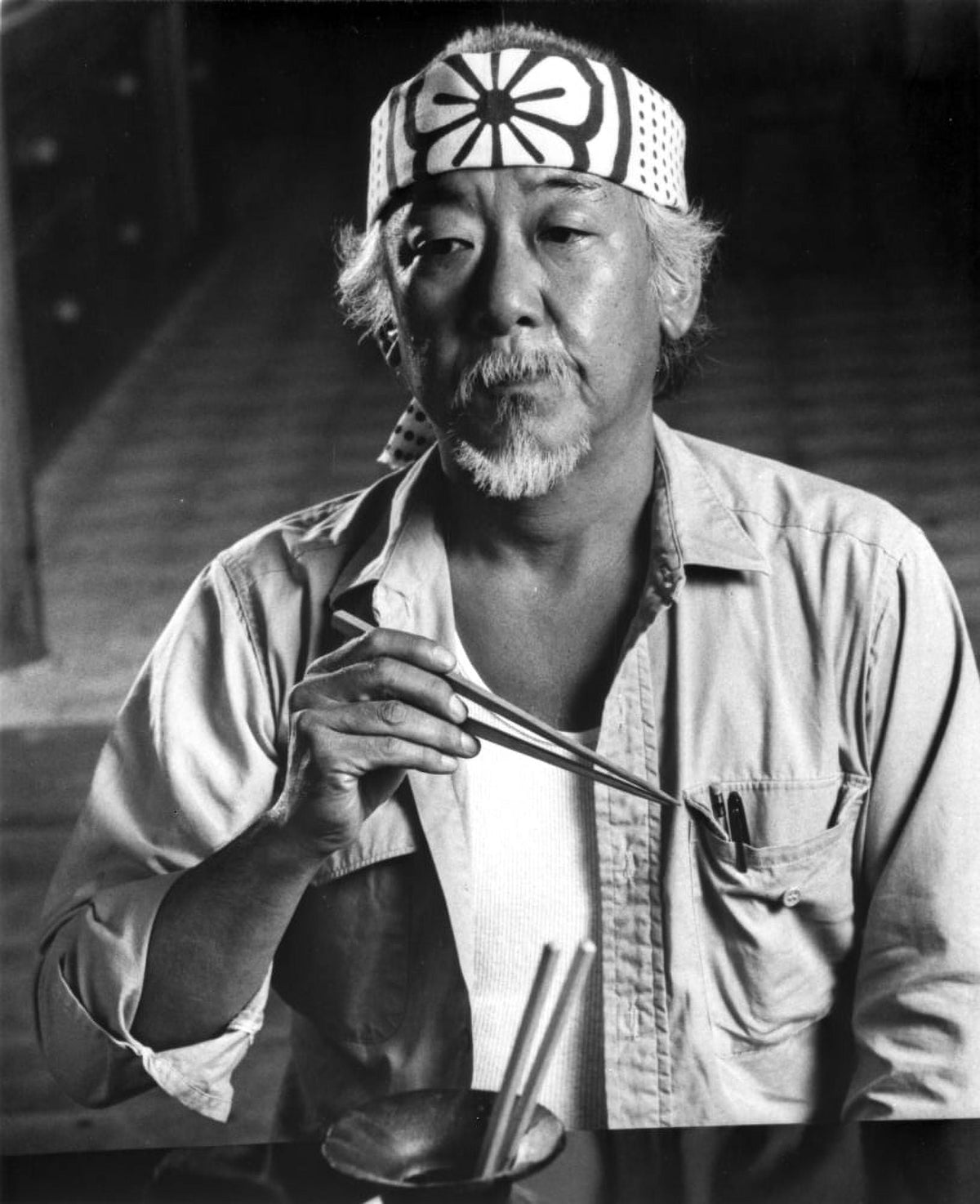 Pat Morita film still photo print of him eating with chopsticks.
