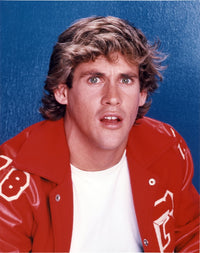 Close-up portrait photo print of Michael Dudikoff against a blue background.