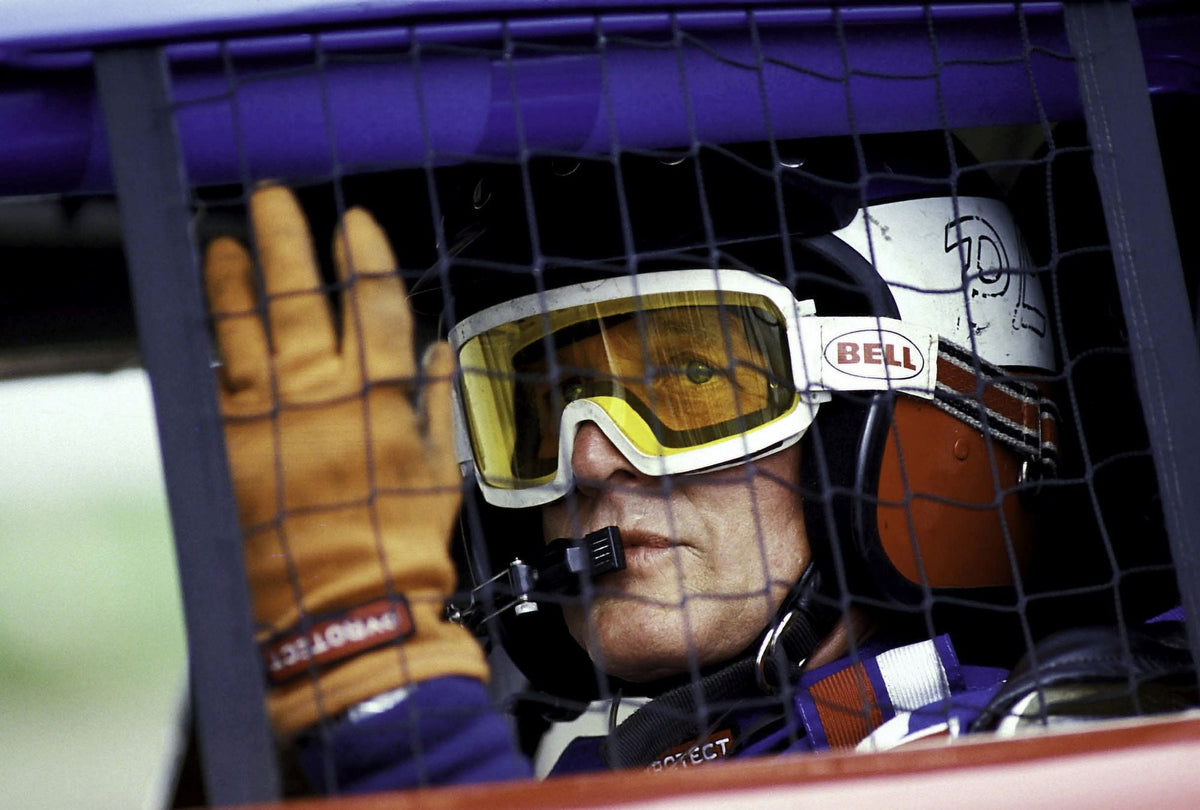 Paul Newman wearing a helmet and goggles in a racing car photo print.