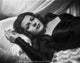 Rita Hayworth lying on bed in black gown photo poster print.