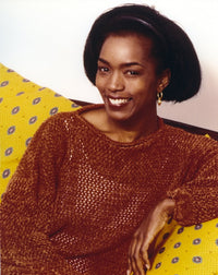 Angela Bassett seated in red photo print, 8 x 10.