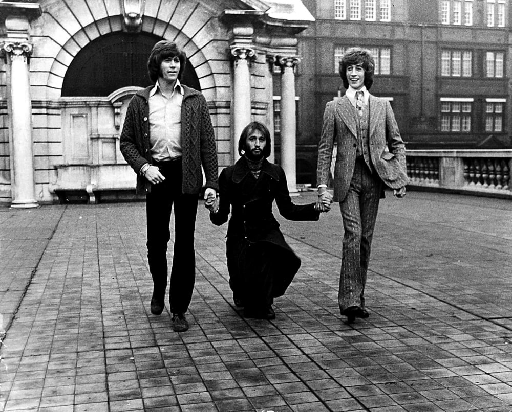 The Bee Gees holding hands photo print, iconic music moment.