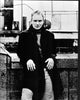 Black and white photo print of Sting leaning on a wall wearing a long coat.