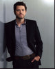 Misha Collins leaning against a wall with hand in pocket photo print