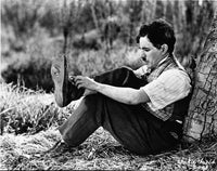 Charlie Chaplin iconic film still photo print putting on a shoe.