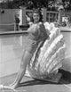 Rita Hayworth leaning on a large clam shell photo print