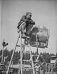 Steve McQueen seated on a ladder in black and white photo print